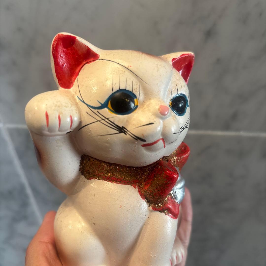 アンティーク大きな瞳や長いヒゲ、まつ毛が美しく、大きなリボンも可愛い招き猫